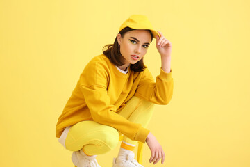 Wall Mural - Stylish young woman on yellow background