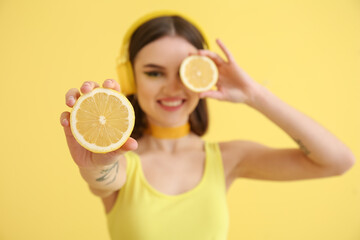 Canvas Print - Stylish young woman with cut lemon on yellow background