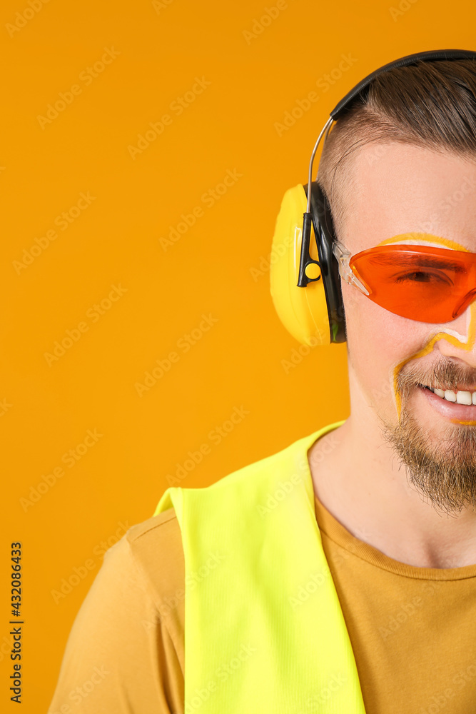 Stylish male worker on yellow background
