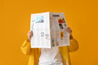 © Pixel-Shot - Stylish young man with newspaper on yellow background