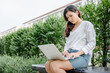 © Maha Heang 245789 - Close-Up of Woman Using Laptop for Business Communication While Sitting on Garden Bench. Businesswoman Use Computer Laptop for Remote Owner Business at The Backyard. Technology Communications Online.