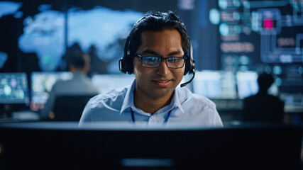 Aufkleber - Portrait of Professional IT Technical Support Specialist Working on Computer in Monitoring Control Room with Digital Screens. Employee Wears Headphones with Mic and Talking on a Call.