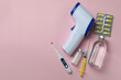 © Atlas - Medical tools and thermometer gun on pink background