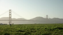 Grass Field And The Golden Gate Bridge During Sunset 