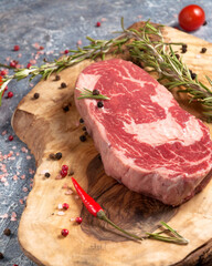 organic raw piece of Prime beef on a wooden Board with spices