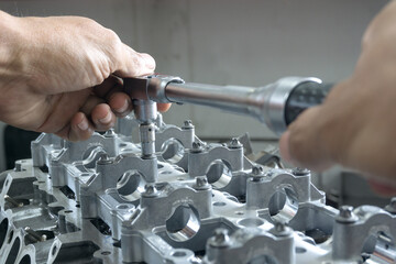 Selective Focus Hand mechanic tightening the nuts using Torque wrench. Mending, repair car in workshop with copy space on background	