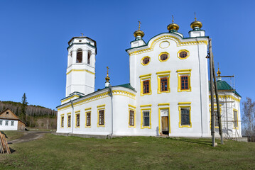 The end of the restoration of the old 1740 church in the village of Klyuchi (Perm Territory, Russia). Traditional Russian style in the architecture of churches. White with decorative details. Spring 