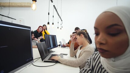 Multi-ethnic IT coworkers developing software in a contemporary office