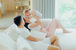 © Mirrorstudio - Father, mother and little son are relaxing on sofa in living room