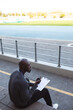 © Wavebreak Media - African american male coach with stopwatch measuring time while sitting on the seats in the stadium