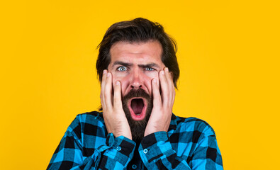 Wall Mural - Dont tell me its true. expressing human emotions. surprised man in checkered shirt. emotional man on yellow background. brutal bearded hipster. mature guy with moustache on face