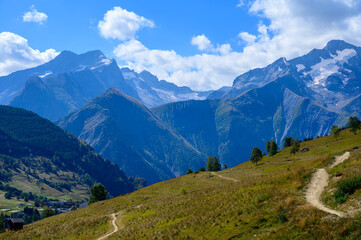 Hiking near ski station Les deux Alpes and view on Alpine mountains peaks in summer, Isere, France