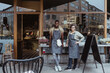 © Maskot - Portrait of smiling male and female coworker outside deli store