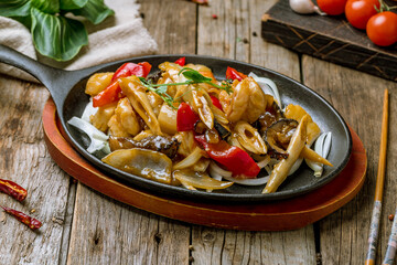 Sticker - Grilled seafood on a wok with vegetables on old wooden table Chinese cuisine