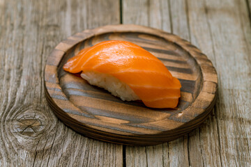 Wall Mural - sushi salmon on a wooden plate on old wooden table