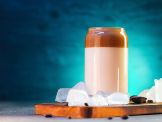 Wall Mural - Dalgona coffee is a stylish glass of summer refreshing drink with coffee and milk on a tiffany color background. Chunks of ice, copy space