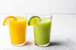 © Елена Швецова - Two glasses of orange, kiwi and avocado smoothies, garnished with lemon wedges on a white table. Selective Focus. Front view
