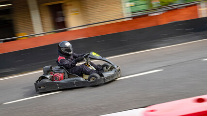 Wall Mural - A panning shot of a racing kart as it circuits a track.