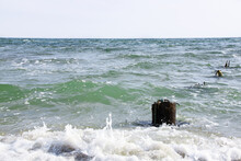 View Of Sea Water And Waves With Old Metal Piles