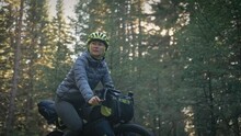 The Woman Travel On Mixed Terrain Cycle Touring With Bike Bikepacking. The Traveler Journey With Bicycle Bags. Magic Forest Park.