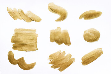 Collection of gold brush strokes isolated on white background.