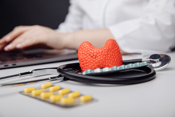 Early diagnosis and treatment of thyroid concept. Model of thyroid gland near stethoscope and doctor