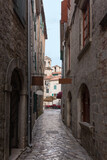 Fototapeta Na drzwi - Narrow street with ancient stone pavers with medieval buildings in old european city Kotor in Montenegro
