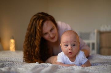 Baby boy playing and bonding with his mother in the bedroom