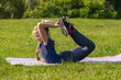 © Андрей Рыков - Portrait of slim caucasian teenage girl doing yoga in summer city park. Bow position (Dhanurasana). Healthy lifestyle. Outdoor sport theme.