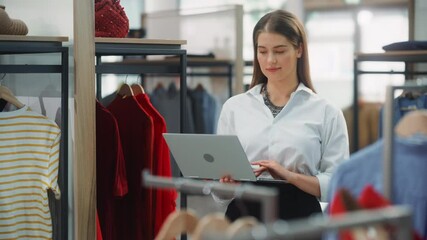 Wall Mural - Clothing Store: Businesswoman and Visual Merchandising Specialist Uses Laptop To Create Stylish Collection. Fashion Shop Sales Retail Manager Checks Stock. Small Business Owner and Designer Works