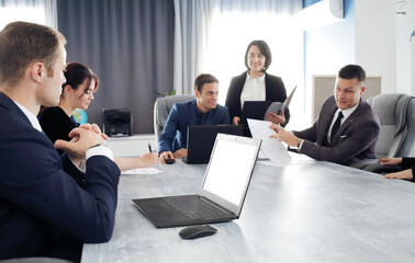 Wall Mural - Group of young business people meeting in the office having fun together discussing an idea