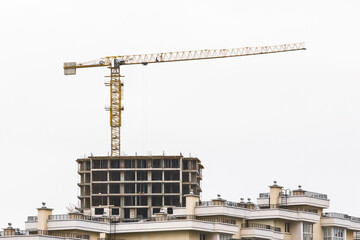 Tower industrial crane on construction site. Building development and work of urban architecture