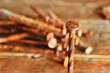 A close up image of several old and very rusted nails on a dark wooden table. 
