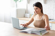 © kucherav - Caucasian beautiful young woman student watching webinar video course or studying online sitting at home in the kitchen, e learning concept