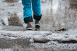 Person in warm shoes standing on wet winter road