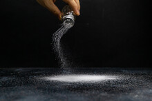 Salt Is Poured From The Salt Shaker On A Black Background