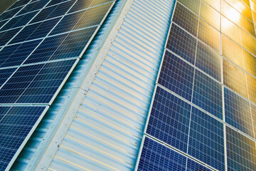 aerial view of surface of blue photovoltaic solar panels mounted on building roof for producing clea