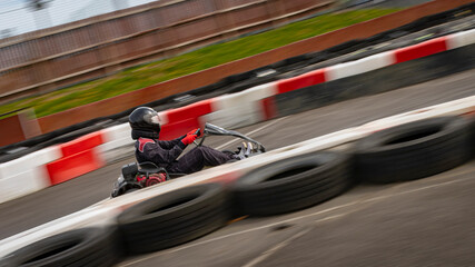 Wall Mural - A panning shot of a racing kart as it circuits a track.