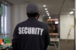 © Flex_Point_Security - Rear view of security guard in uniform patrolling in commercial mall