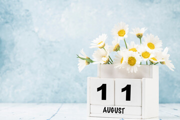 Wall Mural - cube calendar for August with daisy flowers over blue