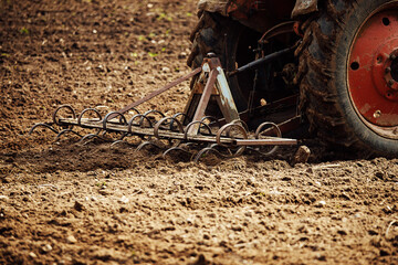 plow tractor plows the land for planting agricultural plants. the farmer cultivates the land in the spring for sowing seeds. iron plow of the mechanized machine