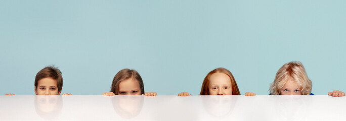 Wall Mural - Two boys and girl looking at camera isolated over blue studio background. Collage.