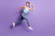 © deagreez - Full body profile photo of cheerful lady run look back wear top jeans isolated on purple color background