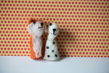 A Red Fox And A Spotted White And Brown Dog Finger Puppet Posing Against A Red Polka Dot And Yellow Background