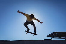 Caucasian Man Jumping And Skateboarding On Sunny Day