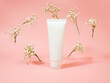 Top view of mockup white squeeze bottle plastic tube and flying gypsophila flowers at light pink background. Natural organic spa cosmetics concept. Front view