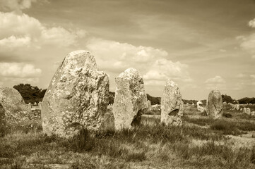 Menhirs - big megalithic monuments near Carnac. Brittany, France. Tourist attractions. Sepia historic photo