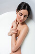 © LIGHTFIELD STUDIOS - pretty young woman with closed eyes touching neck while bathing in milk.