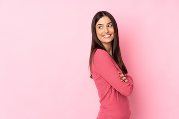 Wall Mural - Young caucasian woman over isolated background with arms crossed and happy