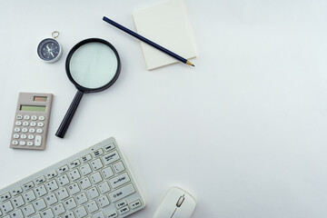 Wall Mural - Business objects of Pc,keyboard,mouse,pencil,compass and calculator,Magnifying glass on White table background